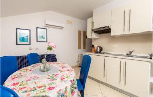 a kitchen with a table with a vase of flowers on it at 2 Bedroom Lovely Apartment In Punta Kriza in Punta Križa