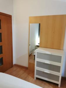 1 dormitorio con tocador blanco y espejo en Apartamento Playa Victoria, en Cádiz