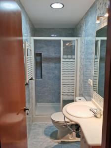 y baño con ducha, aseo y lavamanos. en Apartamento Playa Victoria, en Cádiz