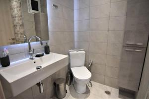 a bathroom with a white toilet and a sink at Magic Balcony on Siviri Chalkidiki. in Siviri