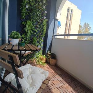 a small balcony with a table and a wall with plants at Frente al Mar EL PALO in Málaga