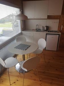 a kitchen with a table and chairs and a window at Savas Uostas in Šventoji +37 photos