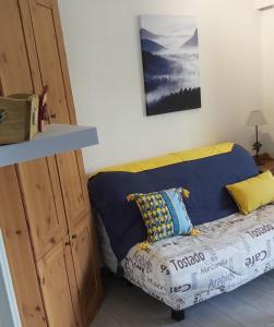 a bed in a room with a blue couch at Studio sur parc proche centre et télécabine in Briançon