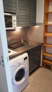 a kitchen with a washing machine and a sink at Studio sur parc proche centre et télécabine in Briançon