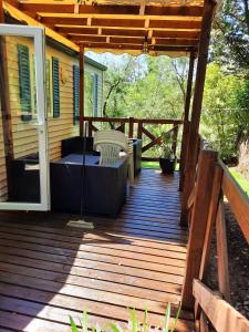 une terrasse en bois avec une table et une chaise. dans l'établissement Mobile-home hyeres var climatisé dans camping avec piscine jusqu'à 6 personnes, à Hyères
