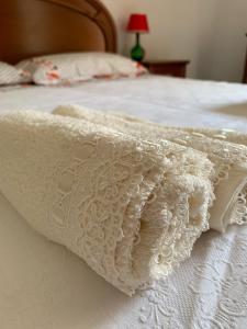una manta blanca encima de una cama blanca en Casa Naneta en San Martino in Pensilis