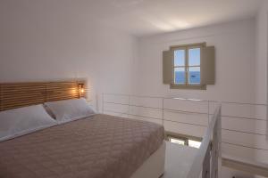 a bedroom with a bed and a window at ASTRAVI in Kimolos