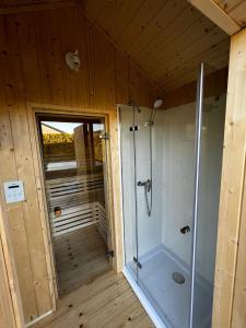 a walk in shower in a wooden room with a shower stall at Morska Mila in Gąski