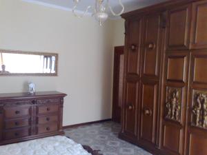 a bedroom with a wooden cabinet and a dresser at Apartment Angioletta in Manfredonia