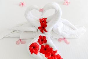 two swans made out of towels with red flowers at Coral Strand Smart Choice in Beau Vallon