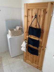 een badkamer met een wasmachine en een deur met handdoeken bij Nad Slováckým sklípkem in Tupesy