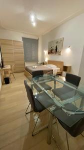 ローマにあるPrati Apartmentのガラスのテーブルとベッドが備わる客室です。