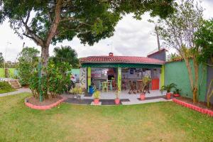 une maison avec une terrasse couverte et une table dans une cour dans l'établissement VOA Pousada Dos Jasmins, à Serra