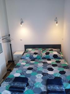 Una cama con edredón en un dormitorio en Apartament z widokiem Łańcut, en Łańcut