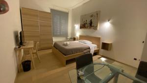 ローマにあるPrati Apartmentの小さなベッドルーム(ベッド1台、ガラス張りのテーブル付)