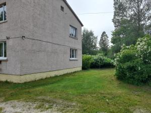 a side view of a building with a yard at Quiet Summer Apartment in Aucugals