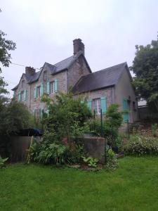una vieja casa de ladrillo con un jardín delante de ella en Une Suite au jardin, en Hyenville