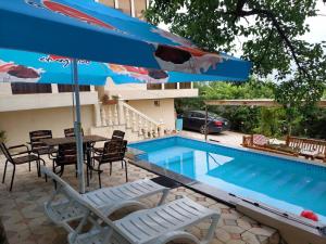 a pool with a table and chairs and an umbrella at hill-fort kutaisi in Kutaisi