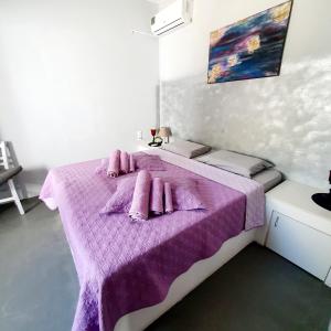 1 dormitorio con cama morada y mantas rosas en Heraklion Gortyn Phaistos House, en Mitrópolis