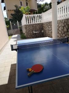 a ping pong table with a ping paddle on it at Villa Kopic in Opatija