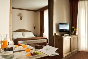 Un pat sau paturi într-o cameră la Hotel Alaska Cortina
