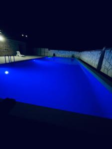 una piscina por la noche con iluminación azul en Spitak tun en Ijevan