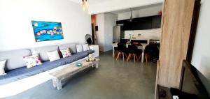 a living room with a blue couch and a kitchen at Heraklion Gortyn Phaistos House in Mitrópolis