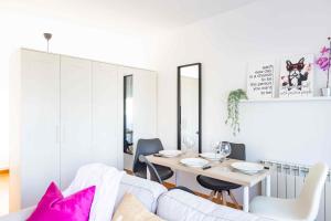 a white living room with a table and a white couch at El Capricho Terrassa. in Terrassa