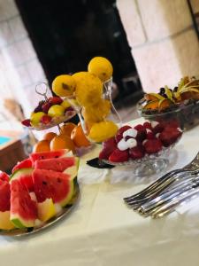 a table topped with plates of fruit and a glass of orange juice at Residence Villa Rosa dei Venti in Cinisi