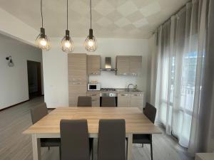 a kitchen with a wooden dining table and chairs at APPARTAMENTI LA CONCHIGLIA in Caorle