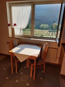 mesa y sillas en una habitación con ventana en Gästehaus Annette Hermes-Hoffmann en Trittenheim