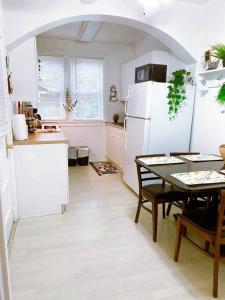 a kitchen with a table and a white refrigerator at (53.1N) Walk to Forest Park in Comfort! in Saint Louis