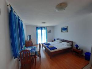 a bedroom with a bed and a table and chairs at Vila Mia in Prizba +68 photos