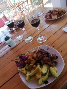 a table with a plate of food and glasses of wine at Hotel Ecoposada Viña de Aldana in Los Santos