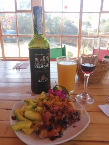 una mesa con un plato de comida y una botella de vino en Hotel Ecoposada Viña de Aldana, en Los Santos