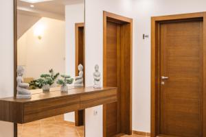 un corridoio con una porta in legno e alcune piante su uno scaffale di Villa Oleander a Ulcinj