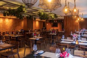 a dining room with tables and chairs and chandeliers at Arena Ipanema Hotel in Rio de Janeiro +34 photos