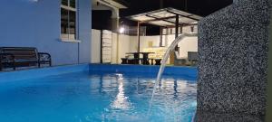 a swimming pool with a water fountain at Rest n Splash by Home Stay Cikgu D'Inapan Kijang in Alor Setar