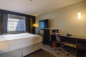 um quarto de hotel com uma cama, uma secretária e um computador em Arc The Hotel em Ottawa