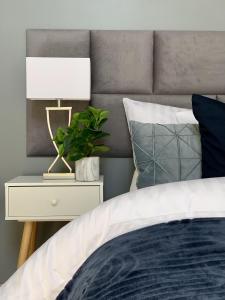 a bedroom with a bed with a lamp and a plant at Apartament Penthouse z widokiem na Śnieżkę i prywatnym parkingiem - by SpaceApart in Jelenia Góra