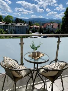 a table and two chairs on a balcony with a view at Apartament Penthouse z widokiem na Śnieżkę i prywatnym parkingiem - by SpaceApart in Jelenia Góra