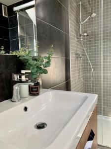 W łazience znajduje się biała umywalka i prysznic. w obiekcie Apartament Penthouse z widokiem na Śnieżkę i prywatnym parkingiem - by SpaceApart w Jeleniej Górze