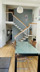 une salle à manger avec une table en verre et des escaliers dans l'établissement Modern City Centre House, à Galway