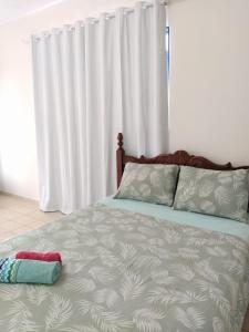 uma cama num quarto com uma cortina branca em Benvivere - Indaiatuba - Seu descanso é aqui! em Indaiatuba