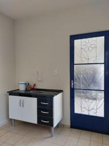 a kitchen with a blue door and a counter with a sink at Benvivere - Indaiatuba - Seu descanso é aqui! in Indaiatuba