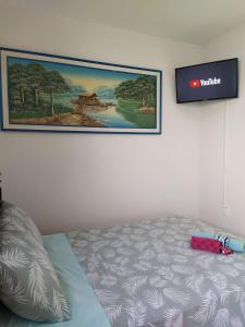 - un lit dans une chambre avec une photo sur le mur dans l'établissement Benvivere - Indaiatuba - Seu descanso é aqui!, à Indaiatuba