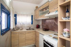 a kitchen with wooden cabinets and a sink and a stove at Peters Studio in Archangelos +12 photos