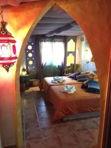 a bedroom with two beds and a chandelier at Casa el Pelaire in Perarrua