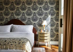 a bedroom with a bed and a black and white wallpaper at The Pinch Charleston in Charleston