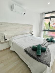 Un dormitorio con una cama con almohadas verdes. en ISLAND SUITES en Arona